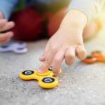 Close-up photo of preschooler boy holding rotating fidget spinners