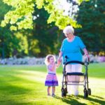 Senior lady with a walker and little girl in a park